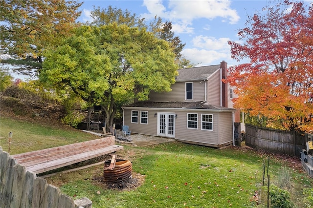 back of property with a yard and french doors