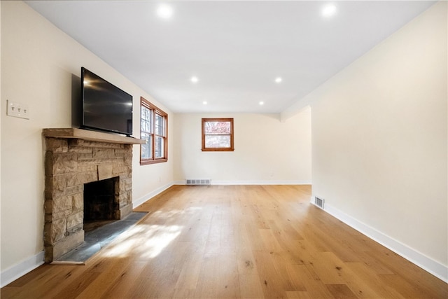 unfurnished living room featuring a fireplace and light hardwood / wood-style floors