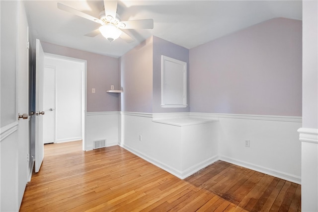 spare room featuring vaulted ceiling, light wood-type flooring, and ceiling fan