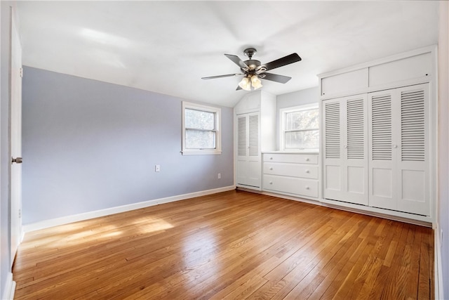 unfurnished bedroom with lofted ceiling, hardwood / wood-style flooring, and ceiling fan