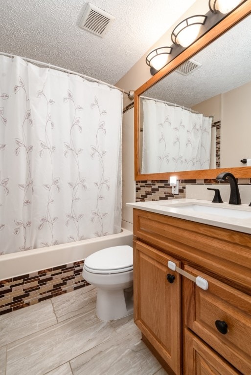 full bathroom featuring shower / bath combo, toilet, vanity, a textured ceiling, and tasteful backsplash