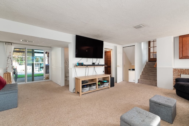 carpeted living room featuring a textured ceiling