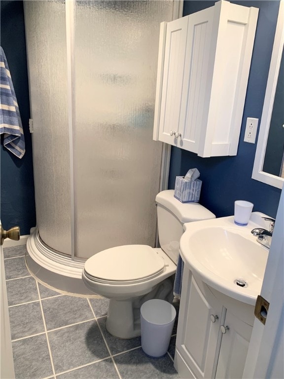 bathroom with toilet, an enclosed shower, vanity, and tile patterned floors