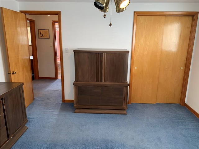 interior space featuring a closet, ceiling fan, and dark carpet