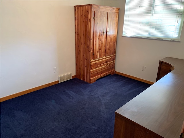 unfurnished bedroom featuring dark carpet