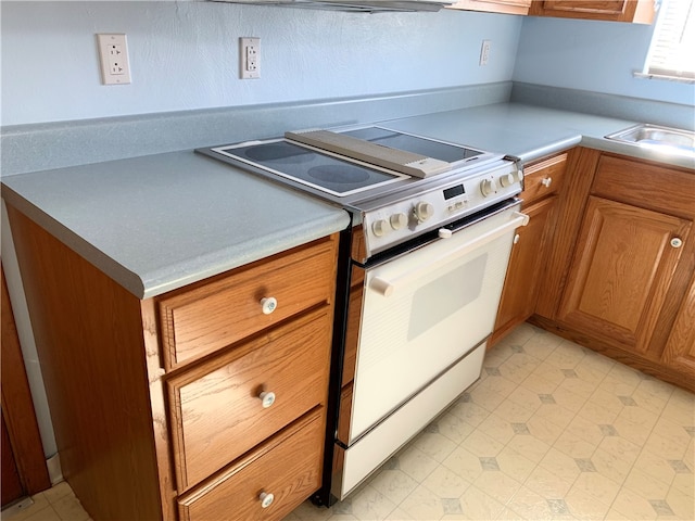 kitchen with white stove and sink