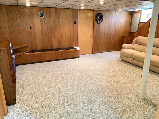 interior space featuring a drop ceiling and wood walls