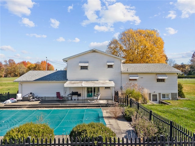 back of property with a patio area and a yard