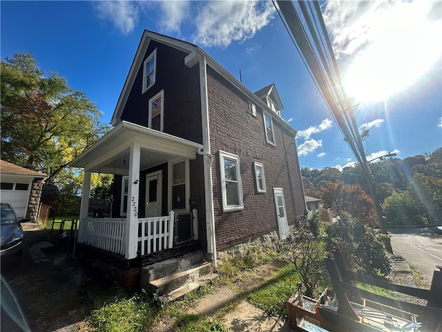 view of property exterior with covered porch and a garage