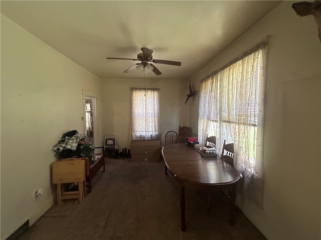 carpeted dining space with ceiling fan