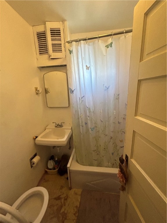 full bathroom featuring sink, toilet, and shower / bathtub combination with curtain