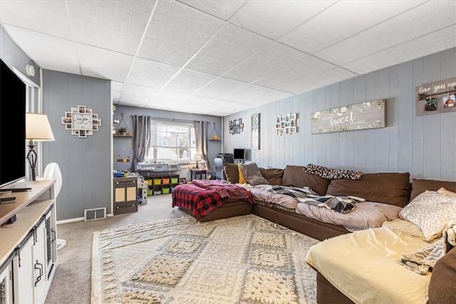 living room featuring carpet flooring and wood walls