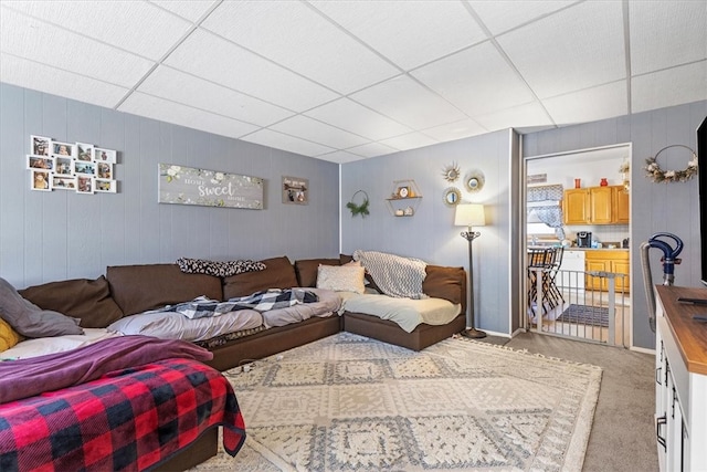 carpeted living room with a paneled ceiling