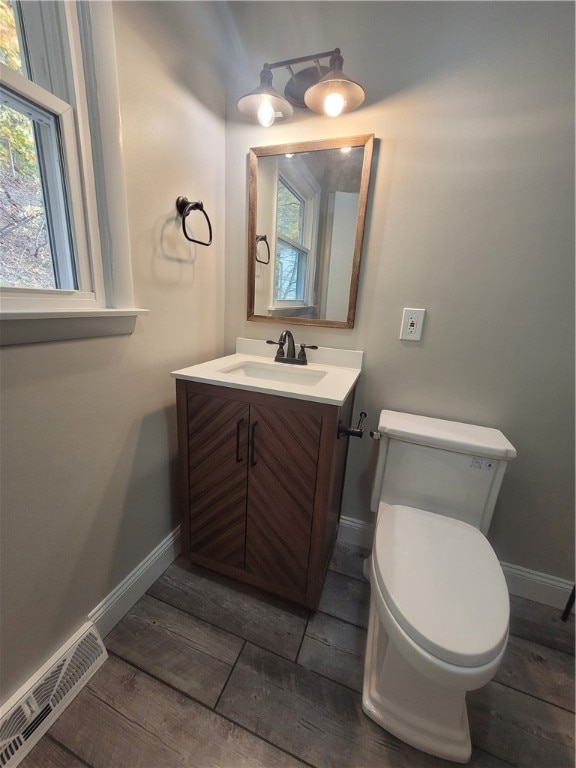 bathroom featuring vanity, toilet, and wood-type flooring