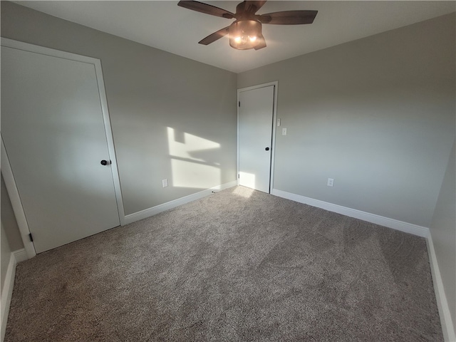 carpeted spare room featuring ceiling fan