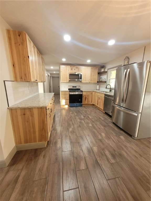 kitchen featuring light brown cabinets, stainless steel appliances, dark wood-type flooring, sink, and light stone counters