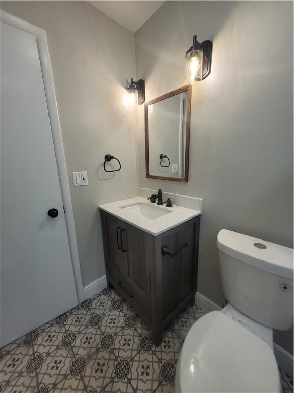 bathroom with toilet, vanity, and tile patterned floors