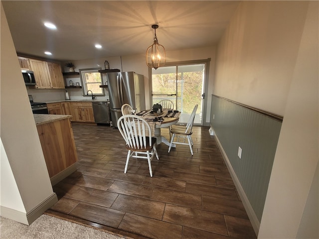 dining area with sink, dark hardwood / wood-style flooring, and a chandelier