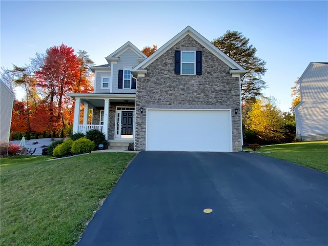 view of front of property with covered porch, a garage, and a front lawn