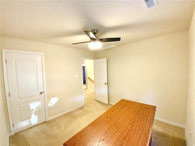 interior space with ceiling fan and light colored carpet