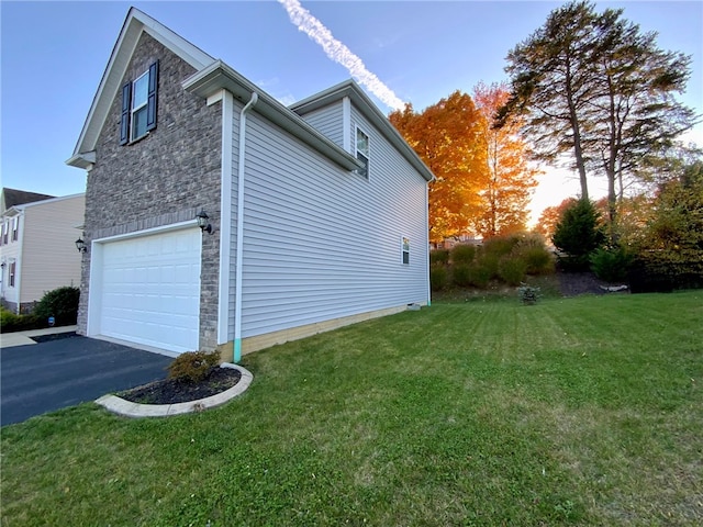 property exterior at dusk featuring a lawn and a garage