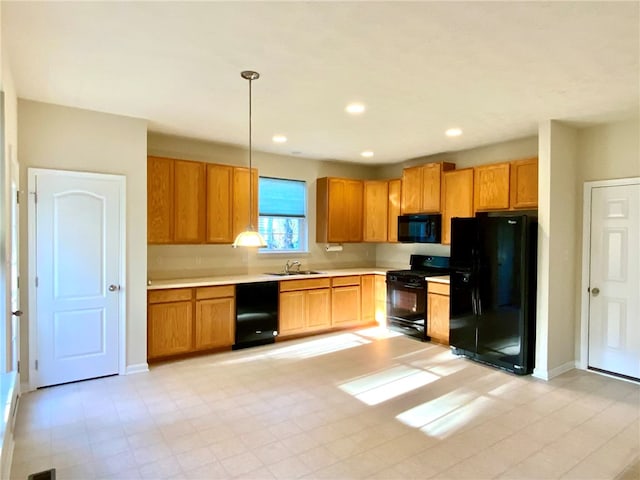 kitchen featuring sink, black appliances, and decorative light fixtures