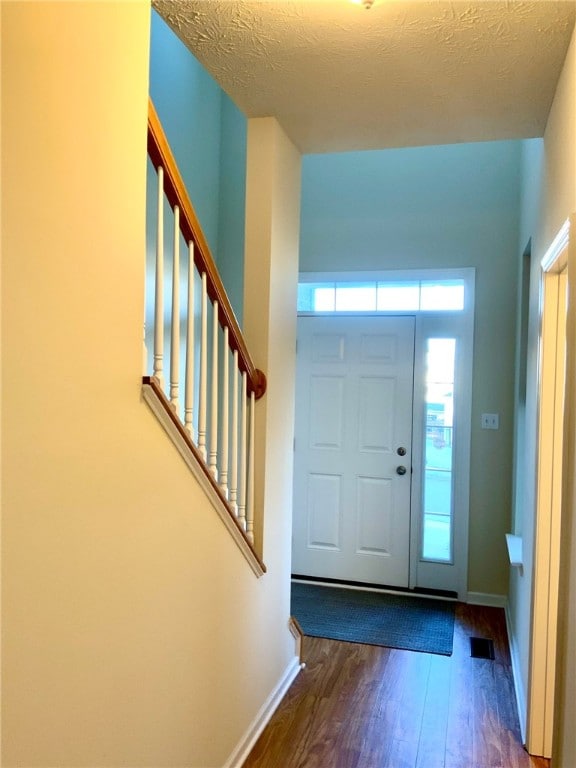 foyer with a textured ceiling and dark hardwood / wood-style flooring