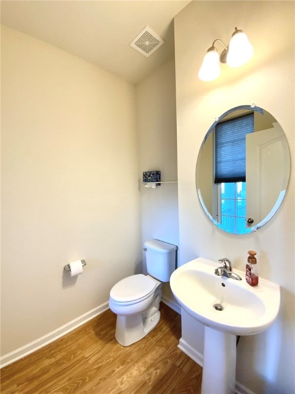 bathroom featuring toilet and wood-type flooring