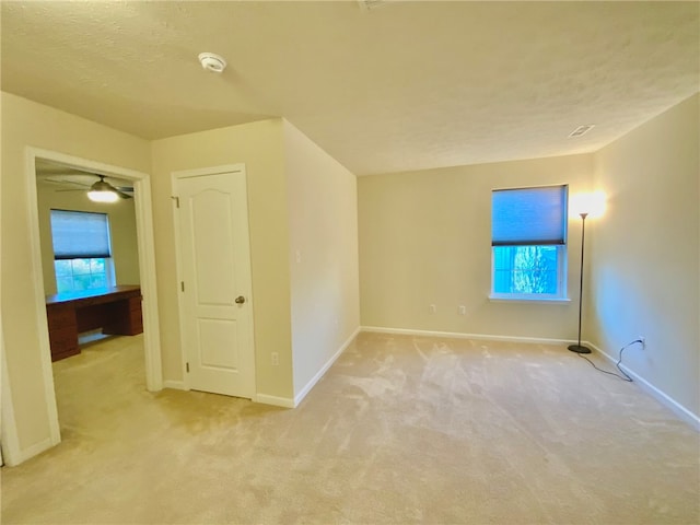 bonus room featuring a textured ceiling, light colored carpet, and ceiling fan