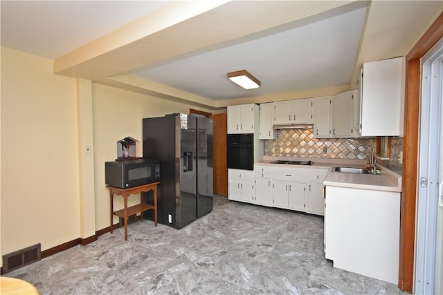 kitchen featuring sink, white cabinets, tasteful backsplash, and black appliances