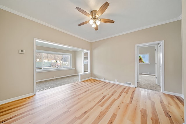 spare room featuring crown molding, light wood-type flooring, and ceiling fan