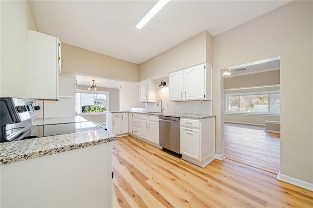 kitchen with light hardwood / wood-style flooring, white cabinets, stainless steel dishwasher, and range