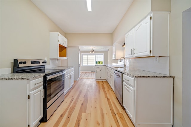 kitchen with white cabinetry, light stone countertops, light wood-type flooring, sink, and stainless steel appliances