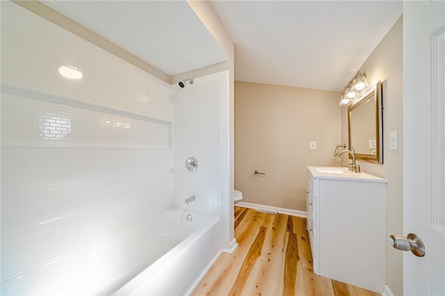 full bathroom featuring toilet, tiled shower / bath combo, vanity, and wood-type flooring