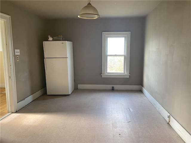 interior space featuring white fridge and decorative light fixtures