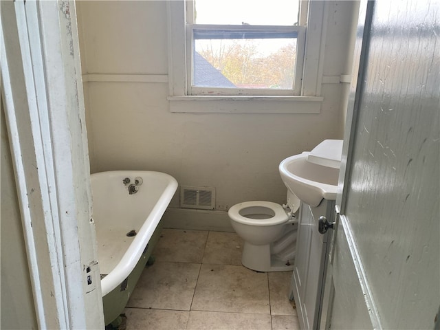 bathroom featuring toilet, vanity, tile patterned floors, and a bathtub