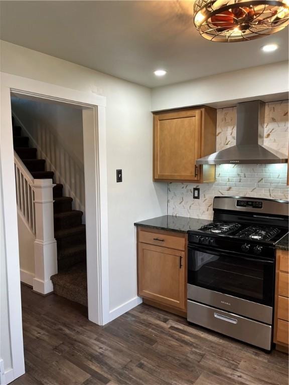 kitchen featuring gas range, dark wood-type flooring, wall chimney exhaust hood, and backsplash