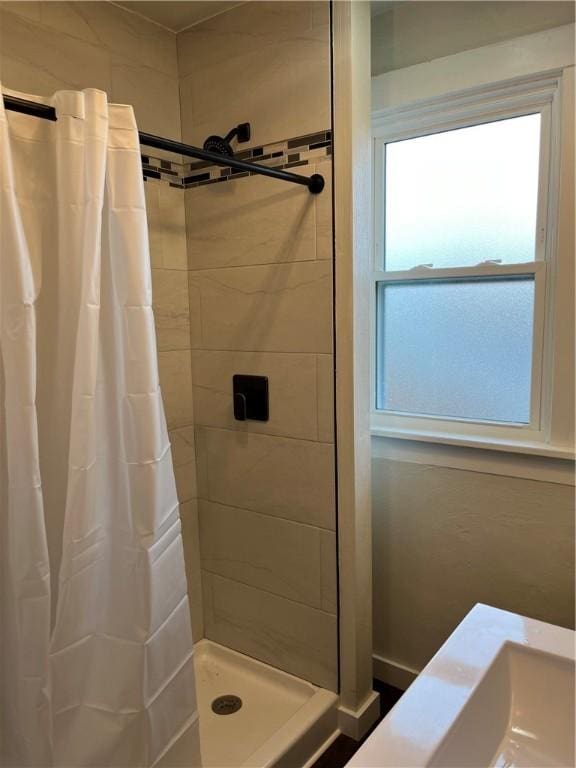 bathroom featuring curtained shower and a healthy amount of sunlight