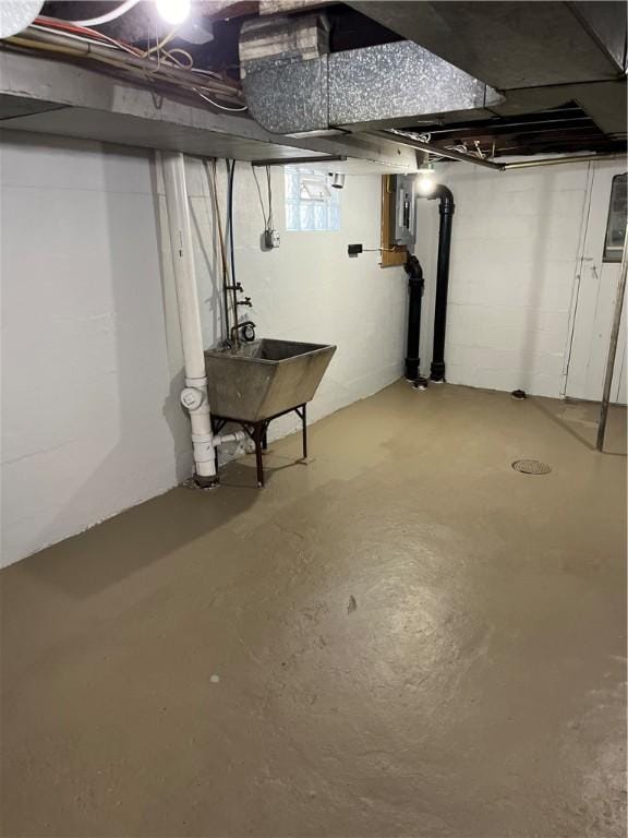 basement featuring electric panel and sink