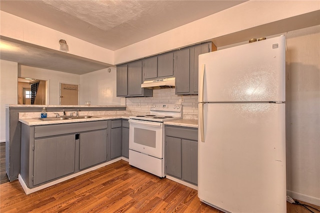 kitchen featuring white appliances, light hardwood / wood-style floors, sink, and gray cabinetry