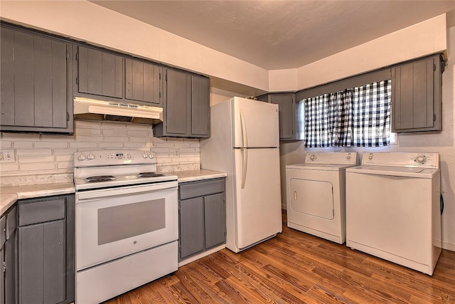 kitchen featuring backsplash, hardwood / wood-style floors, washer and clothes dryer, and white appliances