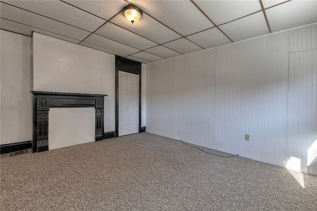 unfurnished bedroom featuring a drop ceiling and carpet floors