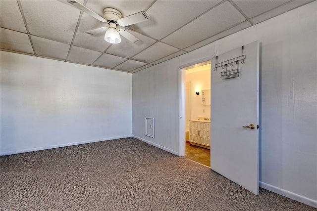 carpeted spare room featuring ceiling fan and a drop ceiling