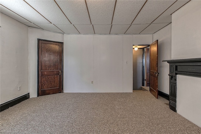 carpeted spare room with a drop ceiling