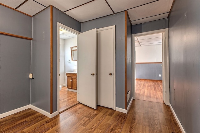 hallway featuring light hardwood / wood-style floors and a paneled ceiling