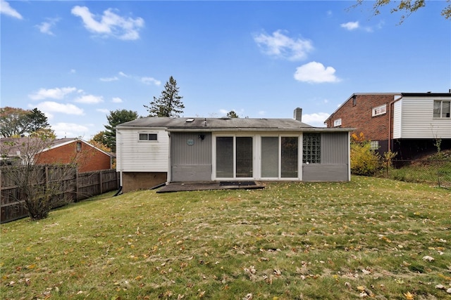 rear view of property with a lawn