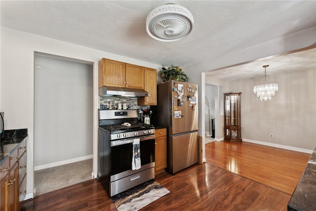 kitchen with decorative backsplash, dark hardwood / wood-style floors, hanging light fixtures, a chandelier, and appliances with stainless steel finishes