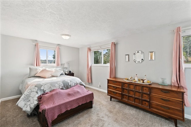 bedroom featuring multiple windows, carpet floors, and a textured ceiling