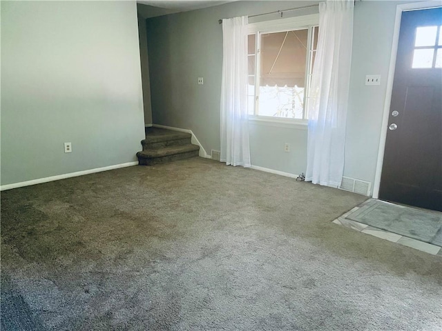 unfurnished living room featuring carpet flooring and plenty of natural light