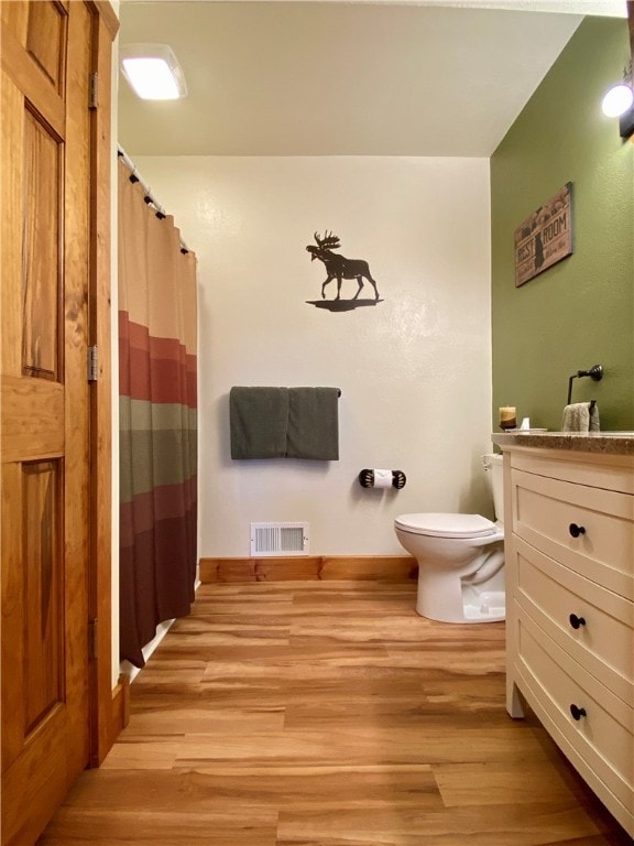 bathroom with vanity, hardwood / wood-style floors, and toilet